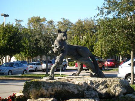 Sculpture of lion laying on tree branch on rock formation